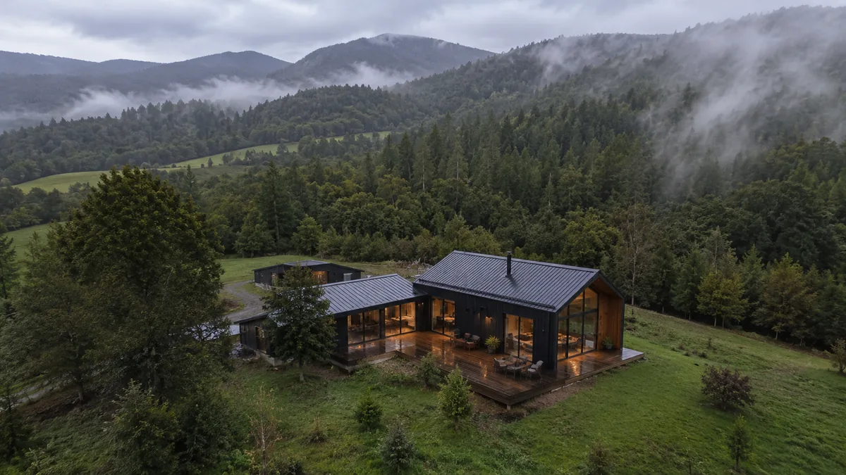 Vista aérea de una vivienda contemporánea en paisaje verde con neblina